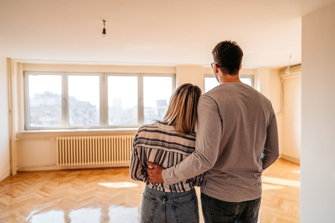 Couple standing in an empty home considering their Truehold home sale options