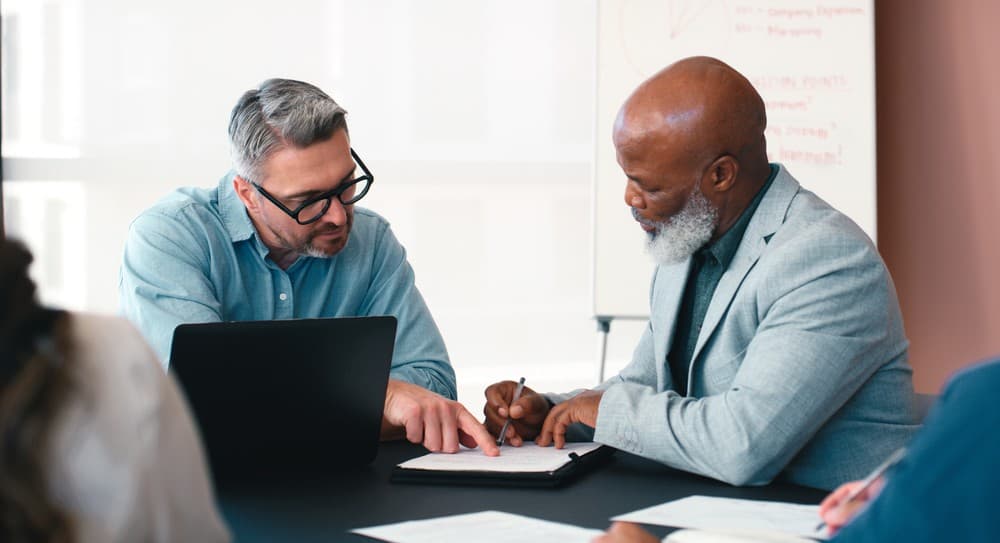 Real estate investor reviewing Truehold Financial financing documents with a lending partner