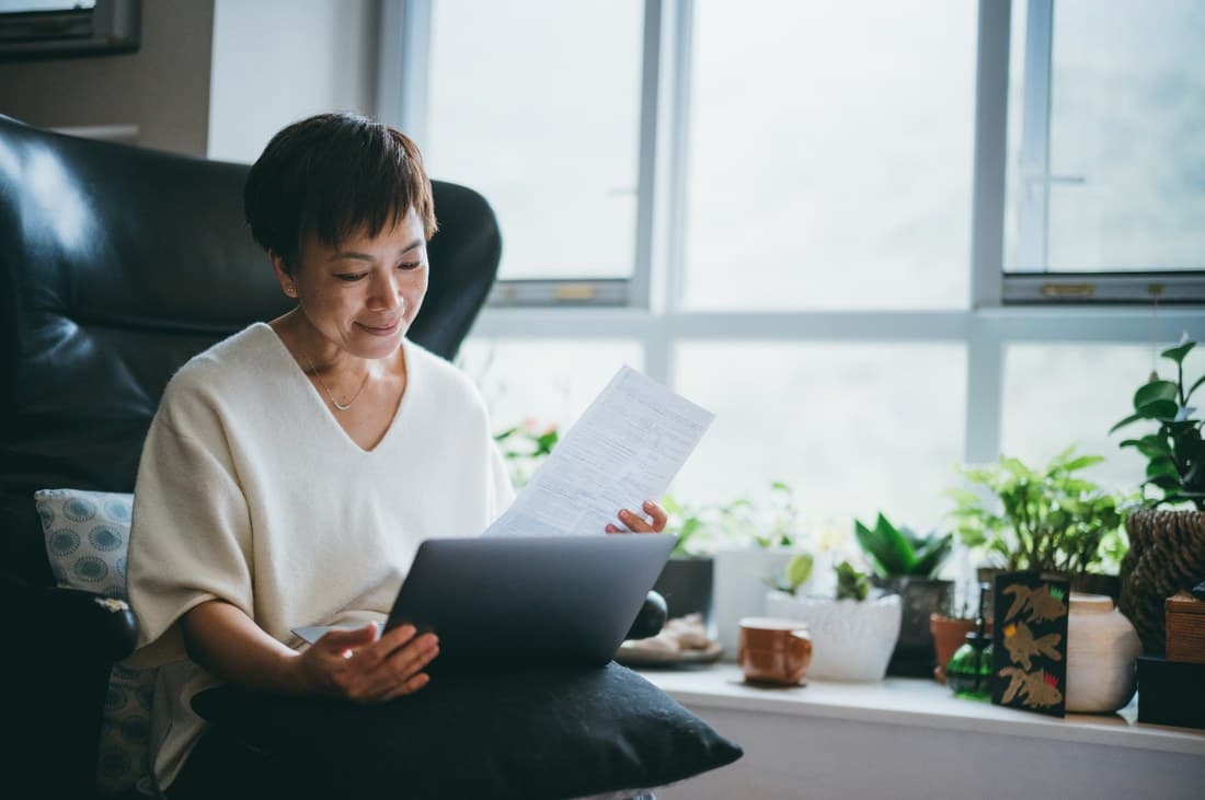 Woman reviewing investment property financing documents at home