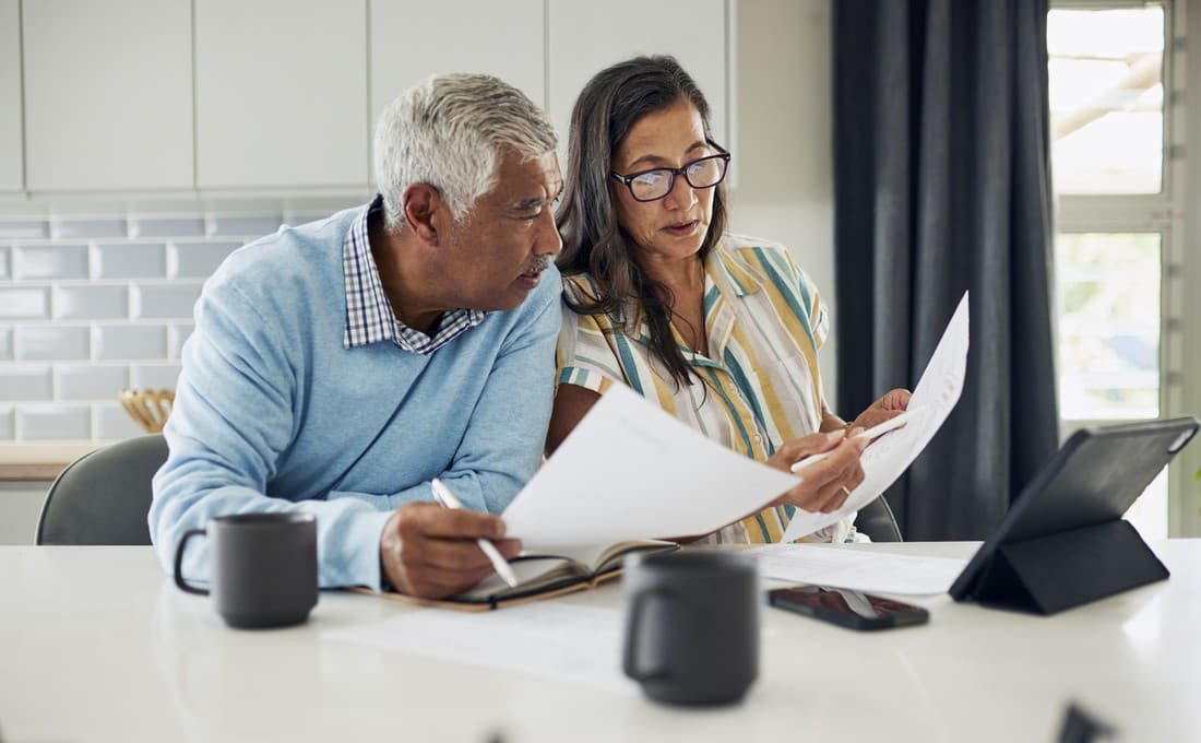Real estate investors reviewing Truehold rental property financing documents at a kitchen table